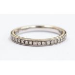A diamond and platinum half set eternity ring, comprising gain set brilliant cut diamonds,