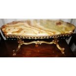 An Onyx topped coffee table, raised on a brass metal Rococo style frame, 44cm high, 120cm wide, 34cm