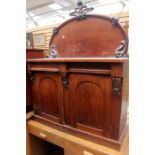 A mid Victorian mahogany chiffonier, the arched shaped back with a scroll carved finial, two