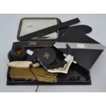 An Art Deco cigarette case; ebony dressing table set, inlaid silver initial, inkwell, mirror and