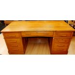 A mid 20th Century oak pedestal desk, fitted with three draws to upper section, one pedestal with