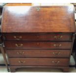 A George III oak and mahogany cross banded bureau, the fall front enclosing a fitted interior,