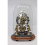 Early 20th Century brass skeleton clock, mahogany stand, dome case with key and pendulum, fusee