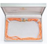 A three strand coral bead necklace with 18ct gold heart shaped clasp, stamped 750, length approx.