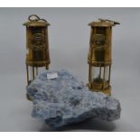 A pair of brass reproduction miners' lamps along with a large piece of crystal, pale blue in colour