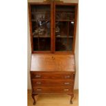 A George V oak bureau bookcase, fitted with two glazed doors, the fall front having a fitted