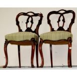 A pair of early Victorian rosewood balloon back dining chairs, raised on reversed scroll feet (2)