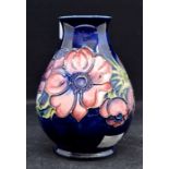 A Moorcroft pottery Anemone pattern baluster shaped vase, tube lined decoration on a blue ground,