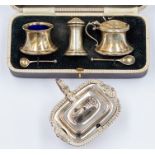 A boxed early 20th Century silver condiment set, Birmingham 1934; along with a silver mustard pot,