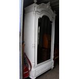 A French 19th Century armoire, painted white, carved pediment, fitted with a single mirror inset