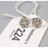 A pair of 18ct gold diamond cluster earrings, the seven stone brilliant cut diamond clusters, in mil