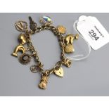 A 9ct gold charm bracelet, suspending numerous charms dolphins, and a pearl in an oyster shell, gro