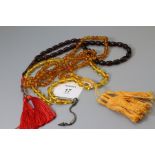 Three vari coloured amber bead necklaces, two with silk tassels gross weight 46.8g Holloway's do no