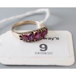 A five stone half hoop ruby ring, the graduated oval cut rubies in claw mounts to plain shank 3.1g,