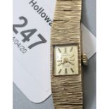 A lady's 9ct gold watch, the rectangular dial within a bracelet of textured, graduated rectangular l