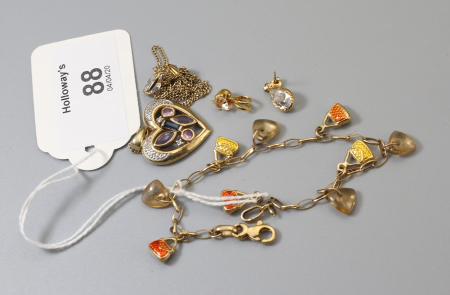 A gem-set heart-shaped pendant to 9ct gold chain, a 9ct gold bracelet with handbag charms, a pair of