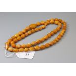 A graduated single row amber bead necklace, the butterscotch beads approximately 90cm length, 59g