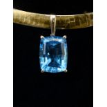 A bi-coloured Omega link necklace, suspending a large London blue topaz, the slightly cushion shaped