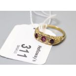 A ruby and diamond seven stone half hoop ring, the three oval cut rubies in carved mount with four s