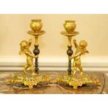 A pair of French ormolu and champleve enamel candle holders,