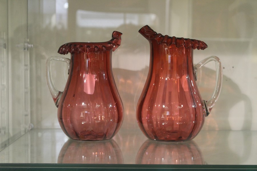 A pair of cranberry glass jugs,