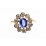 A sapphire and diamond 18ct gold cluster ring, the oval cut sapphire weighing approx. 90ct, with a