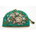 A Victorian beadwork tea cosy, decorated with flowers and foliage on an emerald coloured woven