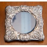 A silver mounted photo frame with embossed decoration.
