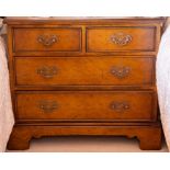 A reproduction walnut diminutive chest of two short over two long cock-beaded drawers, raised on