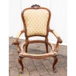 A late Victorian upholstered open armchair, the shield back with shell cresting, the arms with