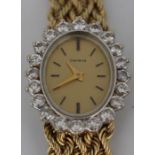 A  ladies diamond set 14ct gold Genève watch, the oval gold tone dial with a diamond claw set