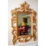 An Italian giltwood wall mirror in Florentine style, 20th Century, the bevelled rectangular plate