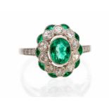 An emerald and diamond platinum gold dress ring, the oval emerald rub-over set to the centre,