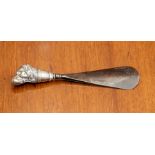 A small shoe horn with silver dog's head handle.