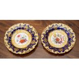 A pair of English porcelain dessert plates, early 19th Century, of lobed form with scroll-moulded