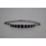A 14ct white gold sapphire and diamond ladies bracelet, set with nine faceted graduated sapphires,