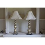 A pair of gilt composite table lamps formed of tapering fluted balls.