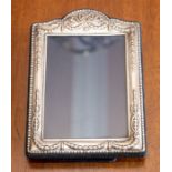 A silver mounted photo frame with embossed decoration.