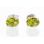 A pair of peridot and silver studs, oval faceted peridots set in four claw mounts, size approx 7mm x