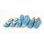 Three pairs of babies shoes, the quilted design of the ankle shoes have a rosette on the front,