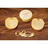 A group of various decorative yellow metal coasters and a bottle opener.