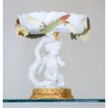 A Moore Brothers comport, modelled as a putto supporting a lily pad, 18.5cm.