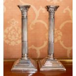 A pair of Edwardian electroplated Corinthian column candle holders, circa 1910, of typical form on