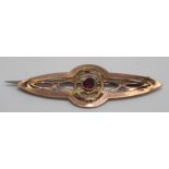 A late Victorian ruby set bar brooch, yellow metal, pierced body and set with a single faceted