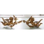 A pair of composite gilt tie-backs modelled as flying putti.