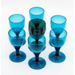 A set of six green glass wine glasses, early 19th Century, the ogee bowls above drawn stems and