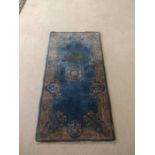 A Persian rug, with central flower boss on a blue field within a flower panel border, 146cm x 74cm.