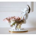 A Moore Brothers centrepiece, modelled as a putti floating beside a lily flower, 23cm high.