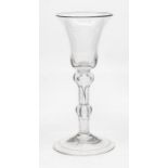 An English balustroid wine glass, circa 1750, the bell bowl above an inverted baluster with lower