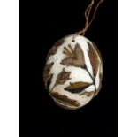 A 17th Century stumpwork embroidered egg, the white probably duck egg worked with raised leaves